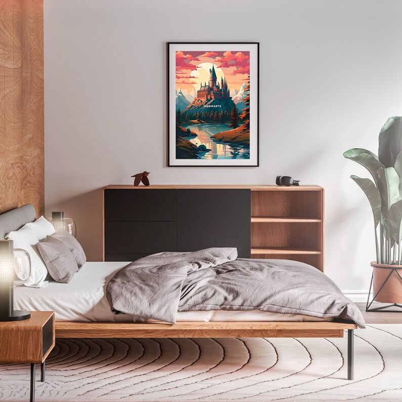 May include: A framed print of a digital illustration of Hogwarts castle, a fictional school of witchcraft and wizardry, set against a backdrop of a mountain range and a lake. The sky is a vibrant orange and pink, with clouds and a setting sun. The text "HOGWARTS" is visible on the castle.