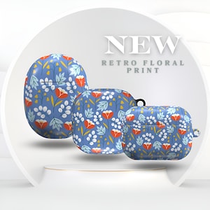 Puede incluir: Tres fundas azules con estampado floral retro. Las fundas tienen un patrón de flores naranjas, hojas blancas y tallos amarillos. El texto "NEW RETRO FLORAL PRINT" se muestra encima de las fundas.