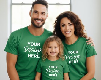 May include: A family of three wearing matching green t-shirts with the text "YOUR Design HERE" printed on them. The father is wearing a green t-shirt, the mother is wearing a green t-shirt, and the child is wearing a green t-shirt.