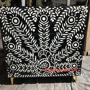 May include: Black and white chest of drawers featuring a peacock design. The chest has a black background with white floral and peacock patterns. It stands on four small, gold-coloured legs. The text "Rolartendercraft" is visible on the front.