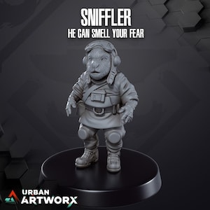 Op de afbeelding: Een grijs, gedetailleerd miniatuurbeeldje van een wezen dat een pilotenhelm en uniform draagt. Het beeldje staat op een zwarte ronde basis. De tekst "SNIFFLER" en "HE CAN SMELL YOUR FEAR" staat boven het beeldje.