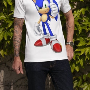 May include: White t-shirt with a blue and red cartoon character of Sonic the Hedgehog giving a thumbs up.
