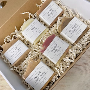 Puede incluir: Una caja de regalo llena de seis jabones artesanales. Los jabones están etiquetados con aromas como Avena Miel y Especias, Lychee Sweet Tea y Cedarwood Coffee House. Cada barra pesa aproximadamente 156 gramos.