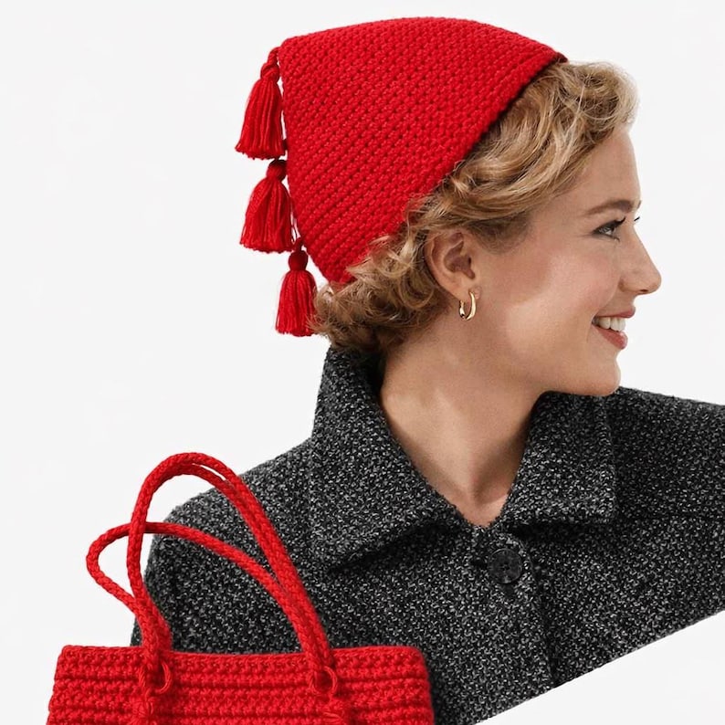 Puede incluir: Un gorro rojo brillante tejido a ganchillo con tres borlas y un bolso de mano rojo tejido a ganchillo a juego. El gorro lo lleva una persona que lleva un abrigo de tweed gris. El bolso tiene dos asas.