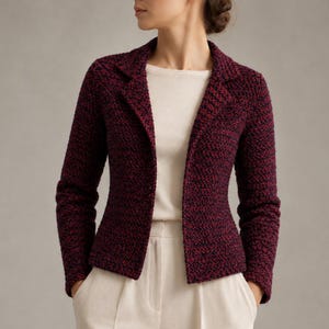 May include: A burgundy blazer with a textured knit pattern. The blazer has a classic lapel and long sleeves. The model is wearing a white top and cream-colored pants. The blazer is open, revealing the top underneath.