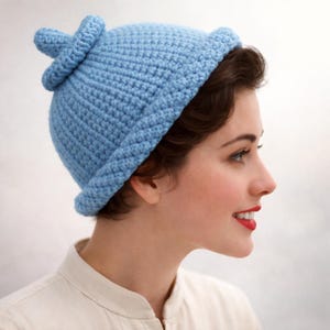 May include: A light blue crochet hat with a distinctive design. The hat has a rounded crown and a brim, with a decorative element on top. The hat is made of a soft, textured yarn, adding a handmade charm to any outfit.