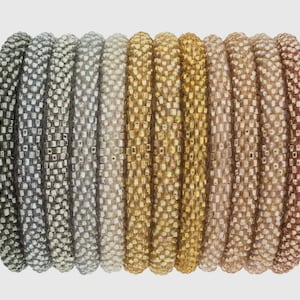 May include: A set of 10 colorful beaded bracelets in shades of silver, gold, and brown. The bracelets are made of small, square beads and are stacked together in a gradient pattern.