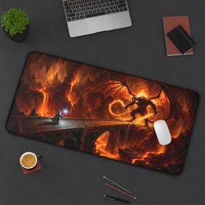 Peut inclure: Un tapis de bureau rectangulaire présentant une illustration fantastique d'un magicien debout sur un pont en pierre face à un grand démon cornu et ailé au milieu d'un paysage volcanique ardent avec de la lave, des braises et des rochers.
