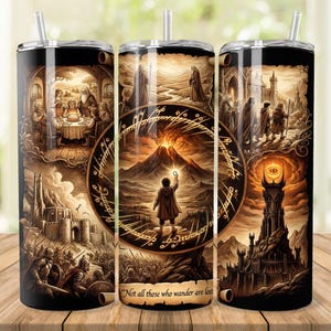 May include: A black stainless steel tumbler with a straw, featuring a fantasy art design. The artwork depicts scenes from a fantasy story, including a gathering, a figure with a light, and a tower with an eye. The text reads "Not all those who wander are lost."