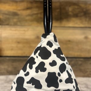May include: Black and white cow print gear shift knob with a black handle.