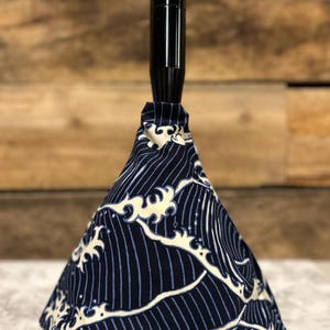 May include: A black gear shift knob with a blue and white wave pattern. The pattern is reminiscent of traditional Japanese art.