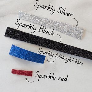 Puede incluir: Imagen de cuatro tiras brillantes en plata, negro, azul medianoche y rojo. Las etiquetas indican: "Sparkly Silver", "Sparkly Black", "Sparkly Midnight blue" y "Sparkle red".