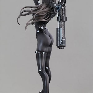 Può includere: Una action figure nera e argentata di un personaggio femminile che indossa una tuta nera con una grossa pistola legata alla schiena. La figura è in posa con un braccio alzato e l'altro che tiene la pistola. La figura è in piedi su una base nera.