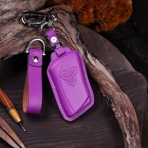 May include: Purple leather key chain with a Celtic knot design and a silver key ring.