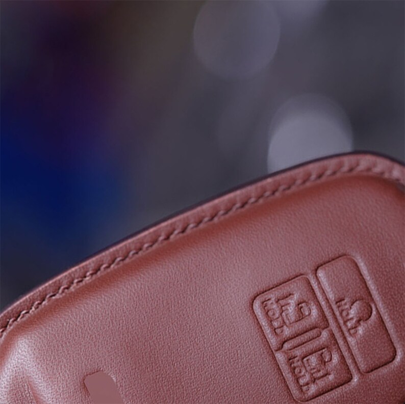 May include: Close-up of a brown leather key fob with three buttons. The buttons are labeled "Hold", "Hold", and "Hold".