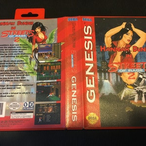 May include: A SEGA Genesis video game case for "Hannah Dundee in Streets of Rage 2." The cover art features a woman in a red top and the game's title. The game's spine is red with the word "GENESIS" in white.