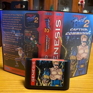 May include: A Sega Genesis game cartridge for Streets of Rage 2: Captain Commando. The cartridge is black with a blue and yellow label featuring a character in a blue and yellow suit. The label also includes the game title and the words "Captain Commando".