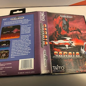 May include: A Sega Genesis video game cartridge for the game Sagai. The cartridge is purple and black with a picture of a futuristic spaceship and a giant robot on the front. The back of the cartridge has a description of the game and a barcode.
