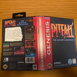 Puede incluir: Un cartucho de juego Sega Genesis para Pitfall: The Mayan Adventure. El cartucho es negro con una etiqueta roja y blanca. La etiqueta presenta el título del juego, una escena de la jungla y el logotipo de Sega Genesis.