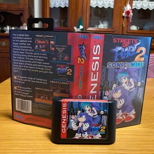 May include: A Sega Genesis game cartridge for Streets of Rage 2, featuring Sonic and Miku on the cover art. The game cartridge is black with a blue and white label. The game is a classic beat 'em up video game.