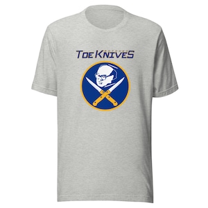 Puede incluir: Una camiseta gris con un logotipo azul y amarillo que dice "Butchered Toe Knives". El logotipo presenta una imagen de dibujos animados de un hombre con gafas y un par de cuchillos cruzados.