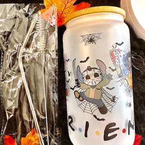 May include: A frosted glass tumbler with a bamboo lid and a Halloween-themed design featuring cartoon characters from the films "Friday the 13th" and "Scream". The tumbler has the words "FRIENDS" written on the bottom with colourful dots. The tumbler comes with a stainless steel straw and a cleaning brush.