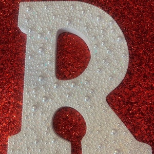 Letra deslumbrante con perlas y cristales de imitación personalizables para cualquier letra.