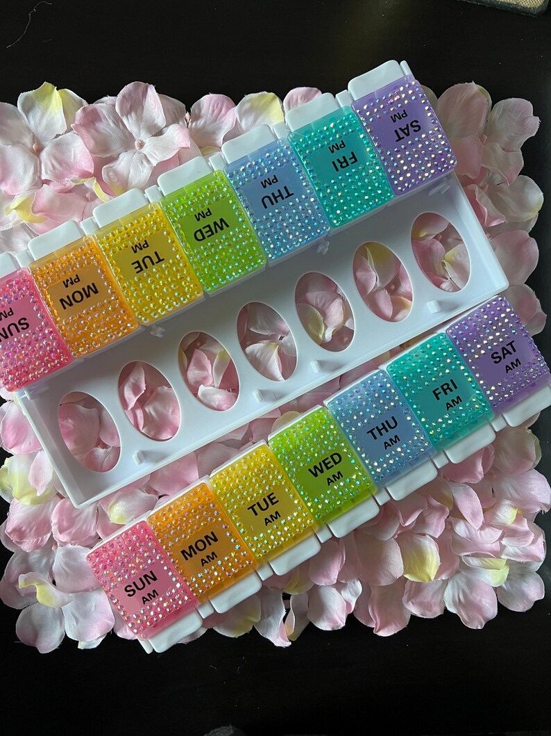 Puede incluir: Un organizador de pastillas arco&iacute;ris con siete compartimentos para cada d&iacute;a de la semana. Los compartimentos est&aacute;n etiquetados con los d&iacute;as de la semana y AM o PM. El organizador est&aacute; decorado con diamantes de imitaci&oacute;n.