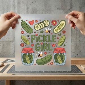 May include: A translucent sheet featuring a colorful "Pickle Girl" design. The design includes green pickles, sliced pickles, jars of pickles, bees, flowers, and hearts. The text "Pickle Girl" is in green script.