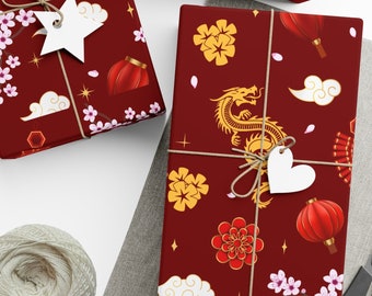 May include: Three red gift boxes with a Chinese New Year theme. The boxes are wrapped in paper with a red background and gold accents. The paper features images of dragons, cherry blossoms, lanterns, and firecrackers. The boxes are tied with twine and have white gift tags.