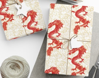 May include: Three gift boxes wrapped in white paper with a red dragon pattern. The boxes are tied with twine and have white paper tags attached.