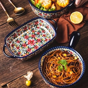 Op de afbeelding: Een witte keramische mok met een zwart handvat en de tekst "But First, Coffee" in een zwarte, handgeschreven lettertype. De mok staat op een wit oppervlak.