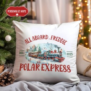 May include: White square pillow with a festive design featuring a vintage train illustration. The text reads "All Aboard, Freddie, Polar Express, Dec. 2025." A personalized name tag is at the top.