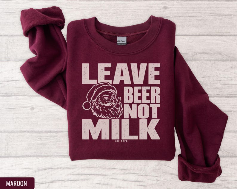 A maroon crewneck sweatshirt with pink text reading LEAVE BEER NOT MILK and a graphic of Santa drinking.