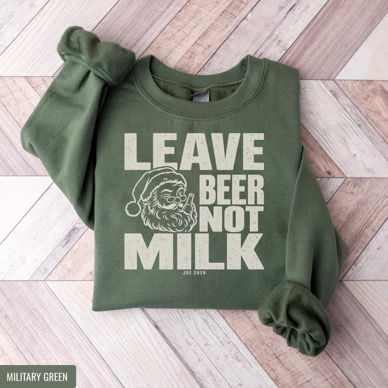 Military green sweatshirt featuring white text that reads Leave Beer Not Milk alongside a Santa graphic.