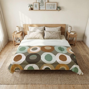 May include: A bed with a wooden headboard and two bedside tables. The bed has a duvet cover with a repeating pattern of large, colourful circles in shades of brown, green, and white. The room has a neutral colour palette.
