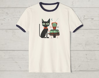 May include: Cream-colored ringer t-shirt with a navy blue trim. The graphic features a black cat wearing a red bow tie, sitting next to a retro diner with the words "diner diner". The design has a vintage, mid-century modern aesthetic.