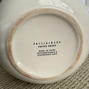 May include: Off-white ceramic serving bowl with the text "POTTERY BARN COFFEE HOUSE" and "MADE IN CHINA MICROWAVEABLE & DISHWASHER SAFE" on the base. The bowl is microwave and dishwasher safe.
