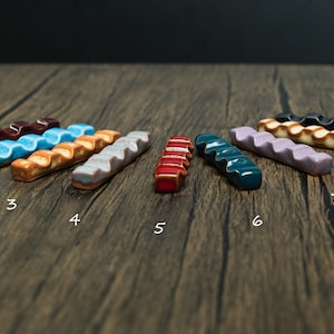 Colorfull paint brush holders on wooden table with numbers under them from 1 to 9.