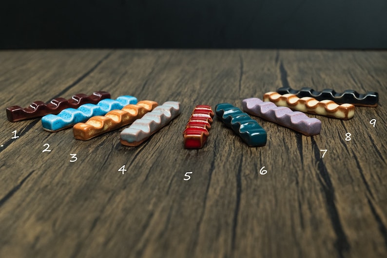 Colorfull paint brush holders on wooden table with numbers under them from 1 to 9.