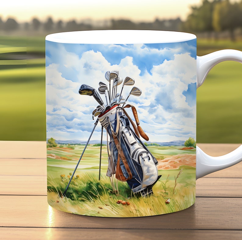 May include: A white ceramic coffee mug with a colorful illustration of a golf bag with clubs on a green golf course. The sky is blue with white clouds.