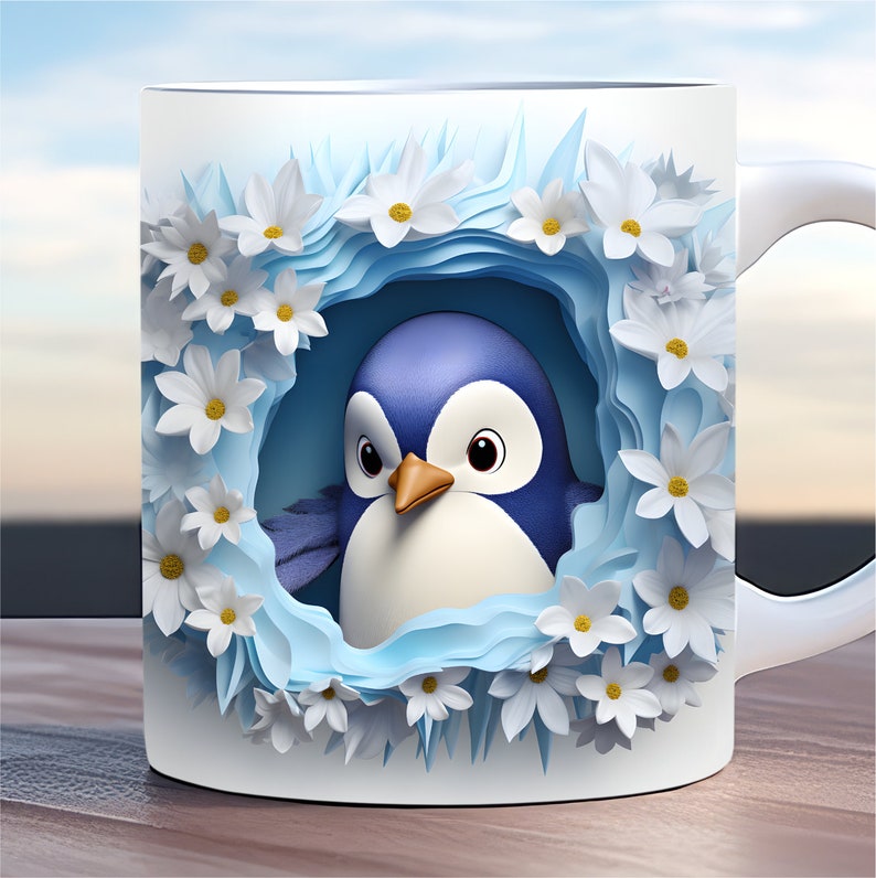 May include: A white ceramic mug featuring a blue penguin peeking out from a nest of white paper flowers. The penguin has a blue body and a white belly.