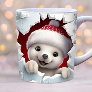 May include: White ceramic mug with a festive design. A white polar bear wearing a red and white Santa hat peeks out from a torn hole in the mug. The bear has a happy expression and is looking directly at the viewer.