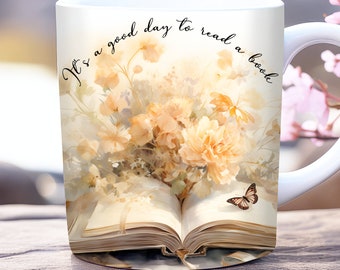 May include: White ceramic mug with a floral design and an open book. The text "It's a good day to read a book" is printed on the mug.