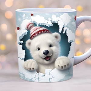 Puede incluir: Taza de cerámica blanca con una escena de invierno que presenta un oso polar con un gorro rojo y blanco a rayas asomándose por un agujero en el hielo. La taza tiene un asa blanca.