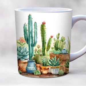 Peut inclure: Une tasse en céramique blanche avec une illustration aquarelle d'une variété de cactus et de succulentes en pots. Les cactus sont verts et ont des fleurs roses. Les succulentes sont vertes et bleues.