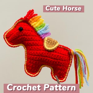 Könnte beinhalten: Handgefertigtes rotes Häkelpferd mit Regenbogenmähne und -schwanz. Das Pferd hat eine gelbe Kontur und einen kleinen Sattel. Der Text auf dem Bild lautet "Cute Horse" und "Crochet Pattern".