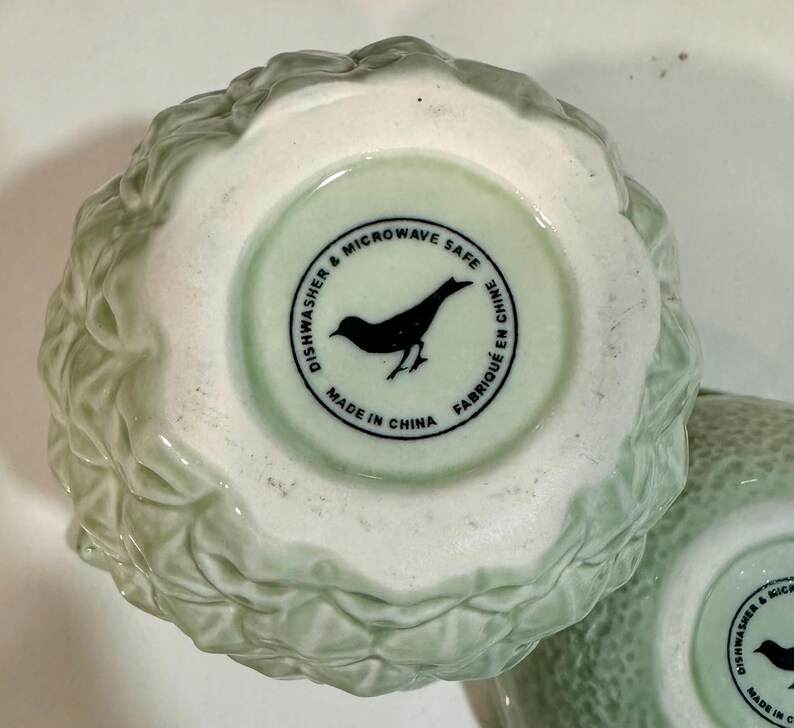 Może przedstawiać: Zielona ceramiczna miska z liściastym wzorem. Na spodzie miski znajduje się biała etykieta z czarnym tekstem: "Dishwasher & Microwave Safe Made in China Fabriqu&eacute; en Chine".