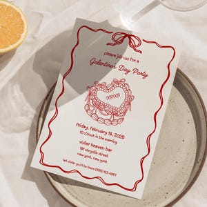 Può includere: Un biglietto d'invito rosso e bianco con un design a forma di cuore rosso e il testo "please join us for a Galentine's Day Party" e "XOXO". L'invito è per venerdì 14 febbraio 2025 alle 22:00 presso l'Outer Heaven Bar, 191 Chrystie Street, New York, New York. Il numero di telefono (555) 123-4567 è incluso.