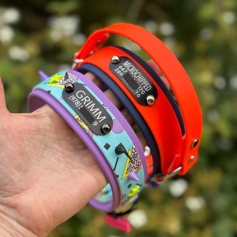 Puede incluir: Tres collares para mascotas que incluyen una banda azul claro con un patr&oacute;n geom&eacute;trico, una banda azul oscuro y una banda naranja brillante. Cada collar incluye una placa de metal negra con texto blanco que dice GRIMM o MICROCHIPPED.